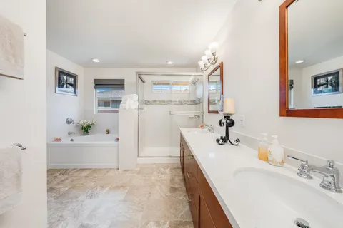 a bathroom with a tub sink and mirror
