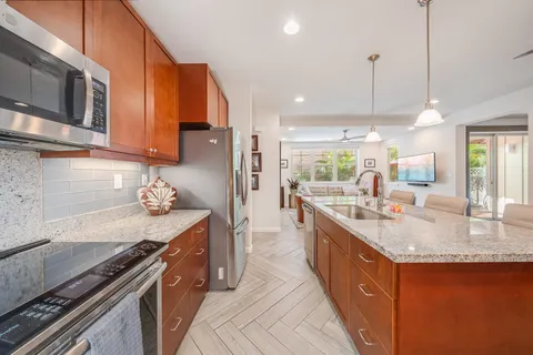 a kitchen with stainless steel appliances granite countertop a stove a sink dishwasher and a refrigerator