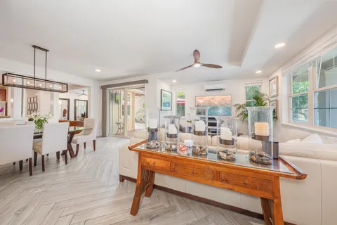 a very nice looking living room with a large dining table and a potted plant with wooden floor