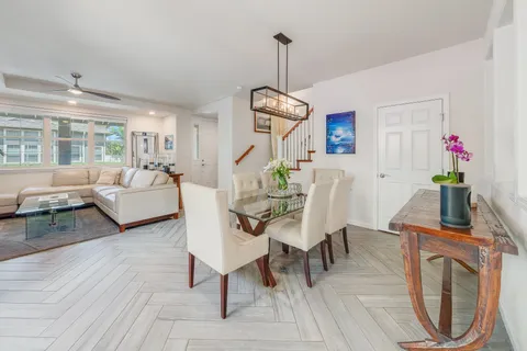 a dining room with furniture a chandelier and wooden floor