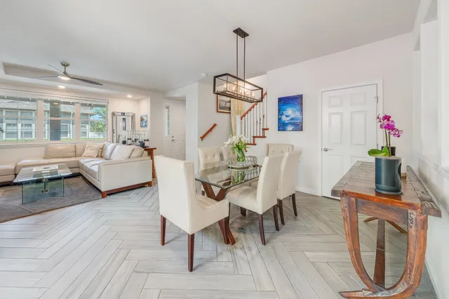 a dining room with furniture a chandelier and wooden floor
