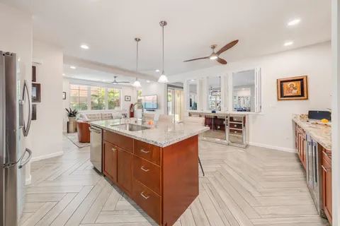 a kitchen with stainless steel appliances kitchen island a large counter top a sink a stove and a refrigerator