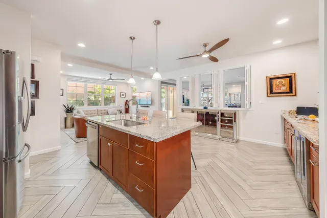 a kitchen with stainless steel appliances kitchen island a large counter top a sink a stove and a refrigerator