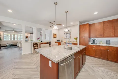 a kitchen with stainless steel appliances granite countertop a kitchen island a stove and a sink