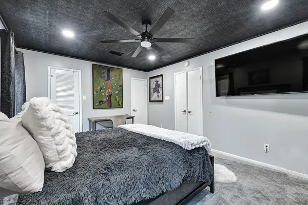 a spacious bedroom with a large bed and a flat screen tv