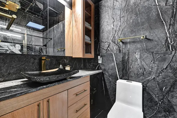 a bathroom with a granite countertop sink a mirror and toilet
