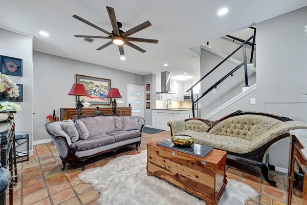 a living room with furniture and a ceiling fan