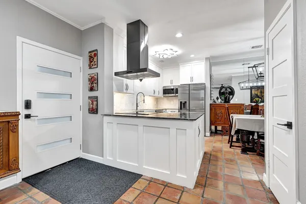 a kitchen with stainless steel appliances kitchen island granite countertop a refrigerator and a sink