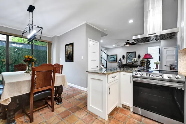 a kitchen with a stove a sink and chairs