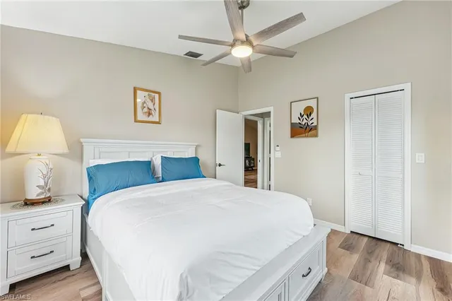 a bedroom with a bed and a lamp on dresser