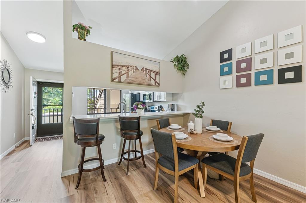 5857 Rattlesnake Hammock Road, Unit 208 Naples, FL 34113 - Photo 7 of 24 a view of a dining room with furniture and wooden floor