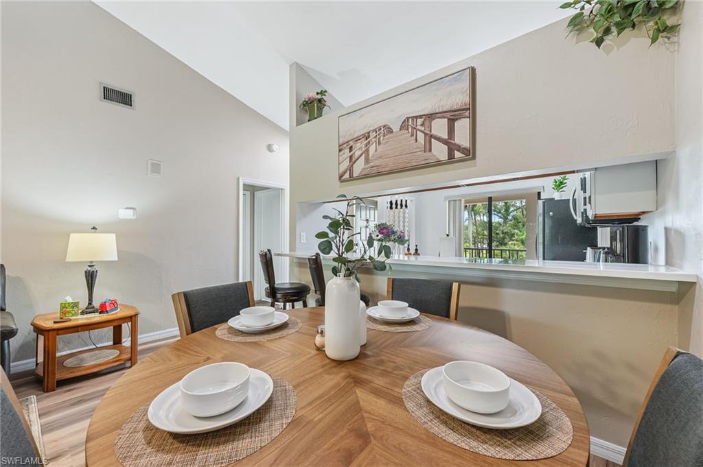 5857 Rattlesnake Hammock Road, Unit 208 Naples, FL 34113 - Photo 8 of 24 a table and chairs in a dining room
