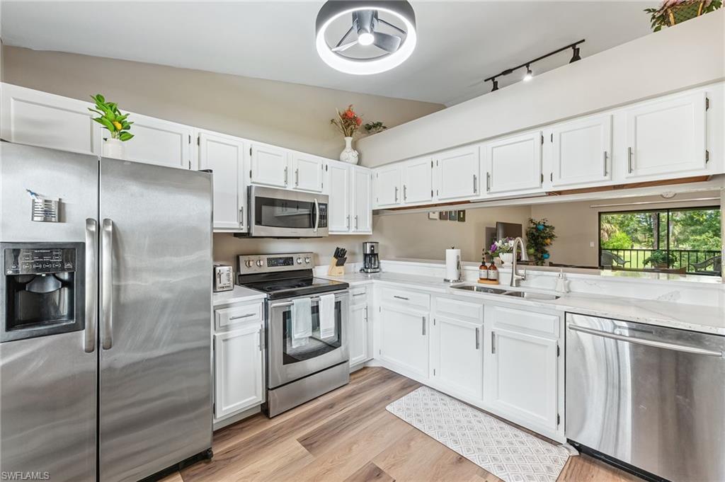 5857 Rattlesnake Hammock Road, Unit 208 Naples, FL 34113 - Photo 10 of 24 a kitchen with cabinets and stainless steel appliances