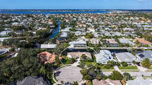 an aerial view of residential houses with outdoor space and trees