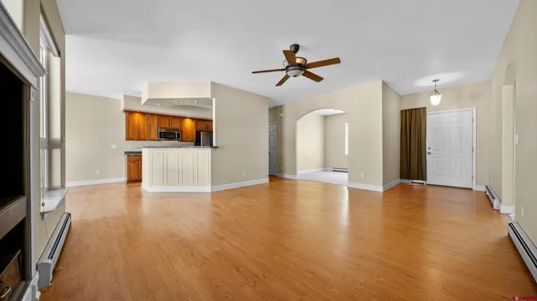 a view of empty room with wooden floor and a window