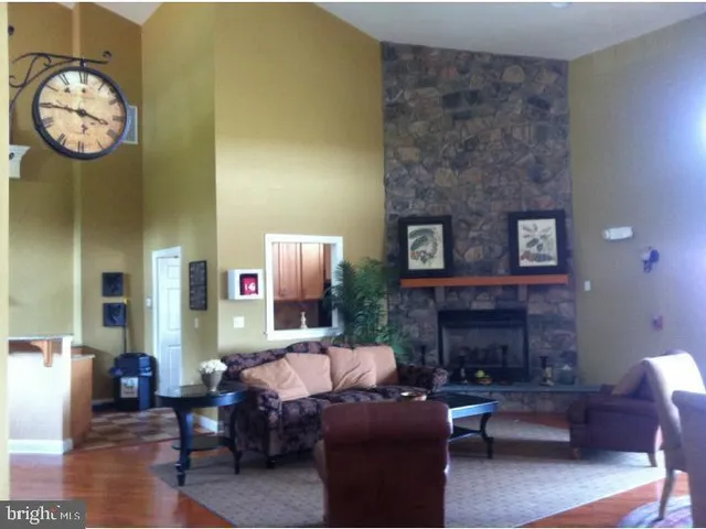 a living room with furniture a fireplace and a wall
