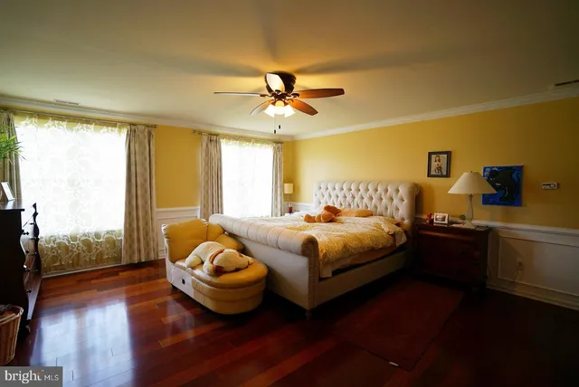 a spacious bedroom with a bed and wooden floor
