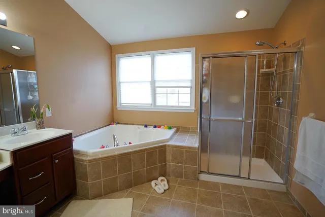 a bathroom with a tub sink and mirror