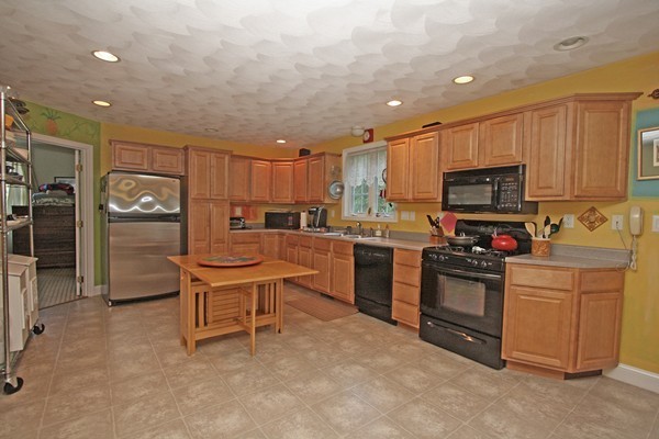 172 Scribner Road Tyngsborough, MA 01879 - Photo 5 of 17 a kitchen with granite countertop a stove top oven and refrigerator