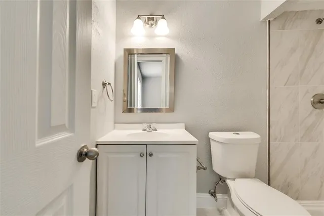 a bathroom with a toilet a sink and mirror