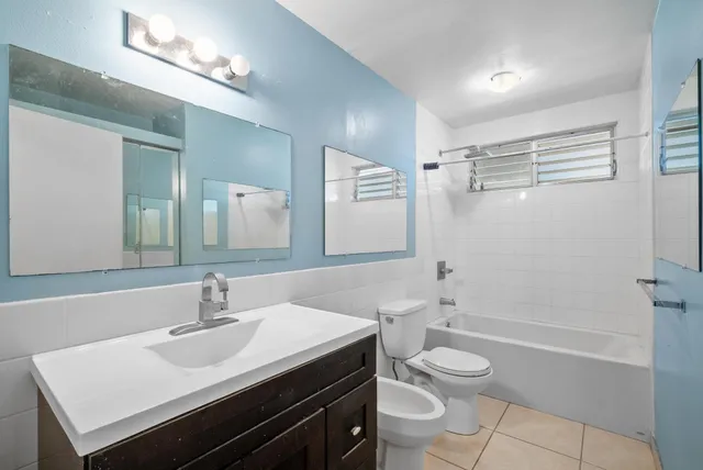 a bathroom with a sink a toilet a mirror and shower