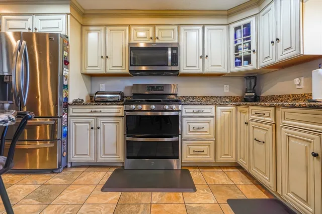 a kitchen with stainless steel appliances granite countertop a stove top oven a refrigerator and a microwave