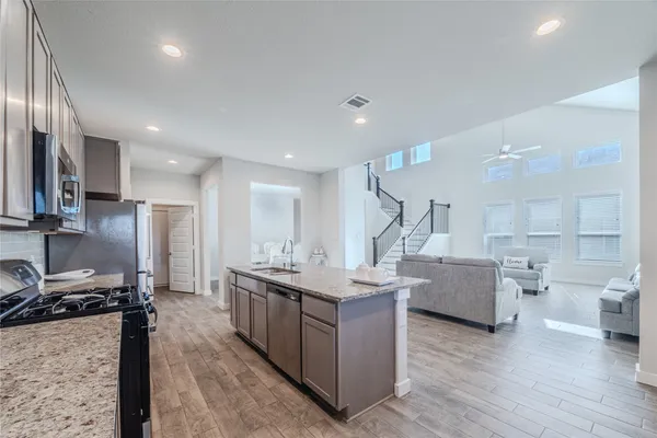 a kitchen with stainless steel appliances granite countertop a sink stove and cabinets