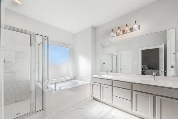 a bedroom with a bed a table and windows