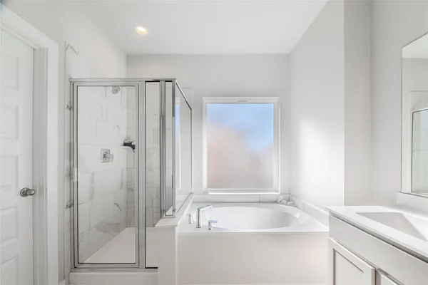 a bathroom with a tub sink and mirror