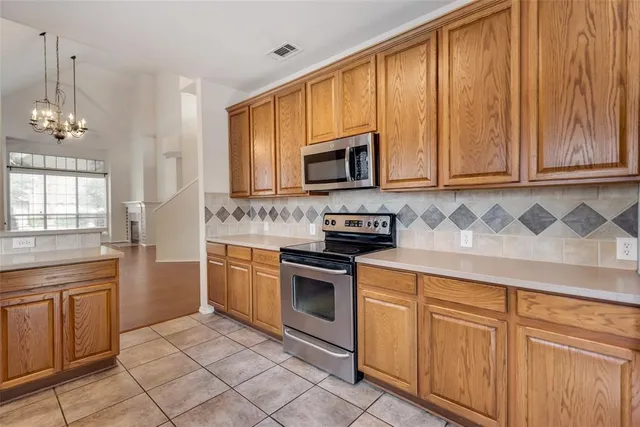 a kitchen with cabinets appliances and a window