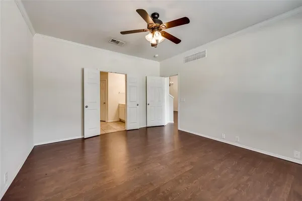a view of an empty room with wooden floor