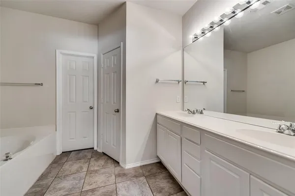 a bathroom with a double vanity sink and a mirror