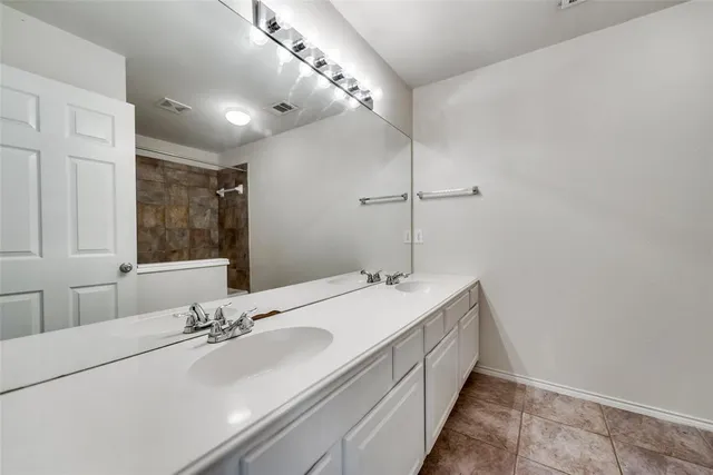 a bathroom with a double vanity sink and a mirror