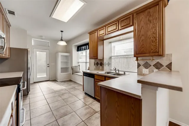 a kitchen with stainless steel appliances a sink stove and cabinets