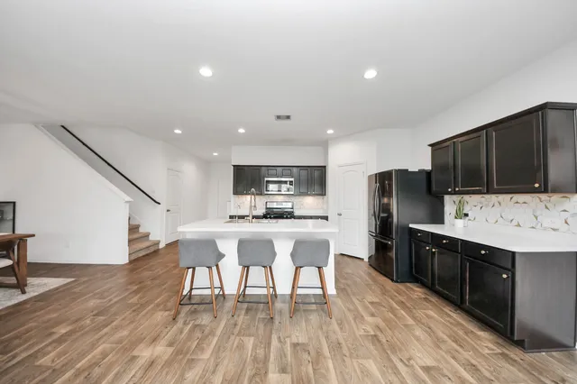 a kitchen with stainless steel appliances granite countertop a sink stove and refrigerator