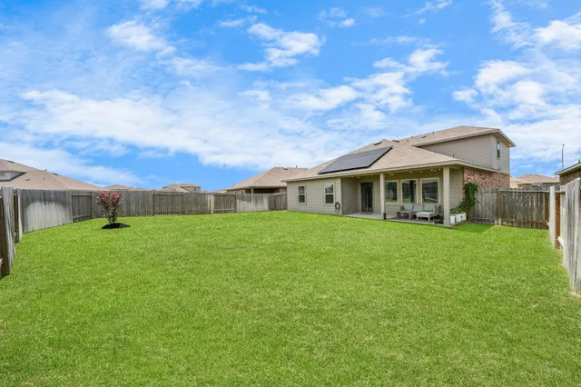 a patio with table and chairs and potted plants