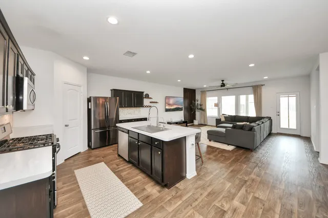 a kitchen with stainless steel appliances granite countertop a sink stove and refrigerator