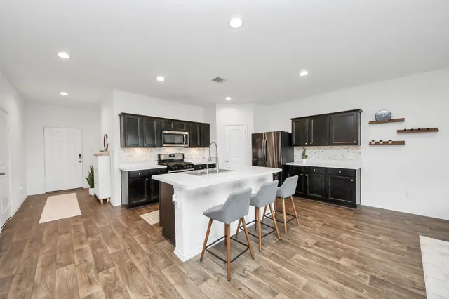 a kitchen with stainless steel appliances a white stove top oven a sink dishwasher and a refrigerator