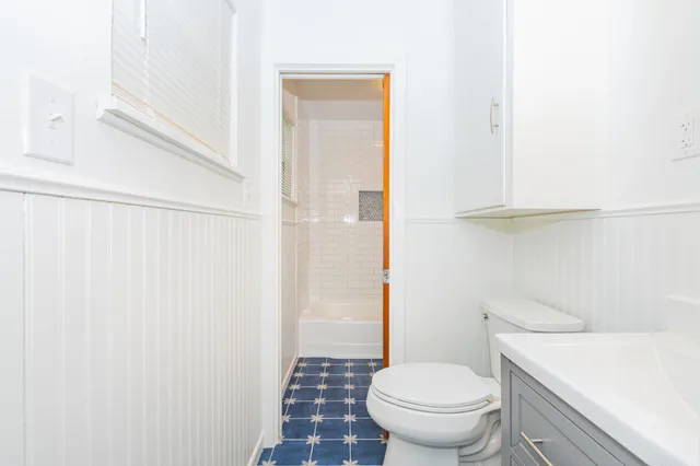 a white toilet sitting next to a bathroom sink