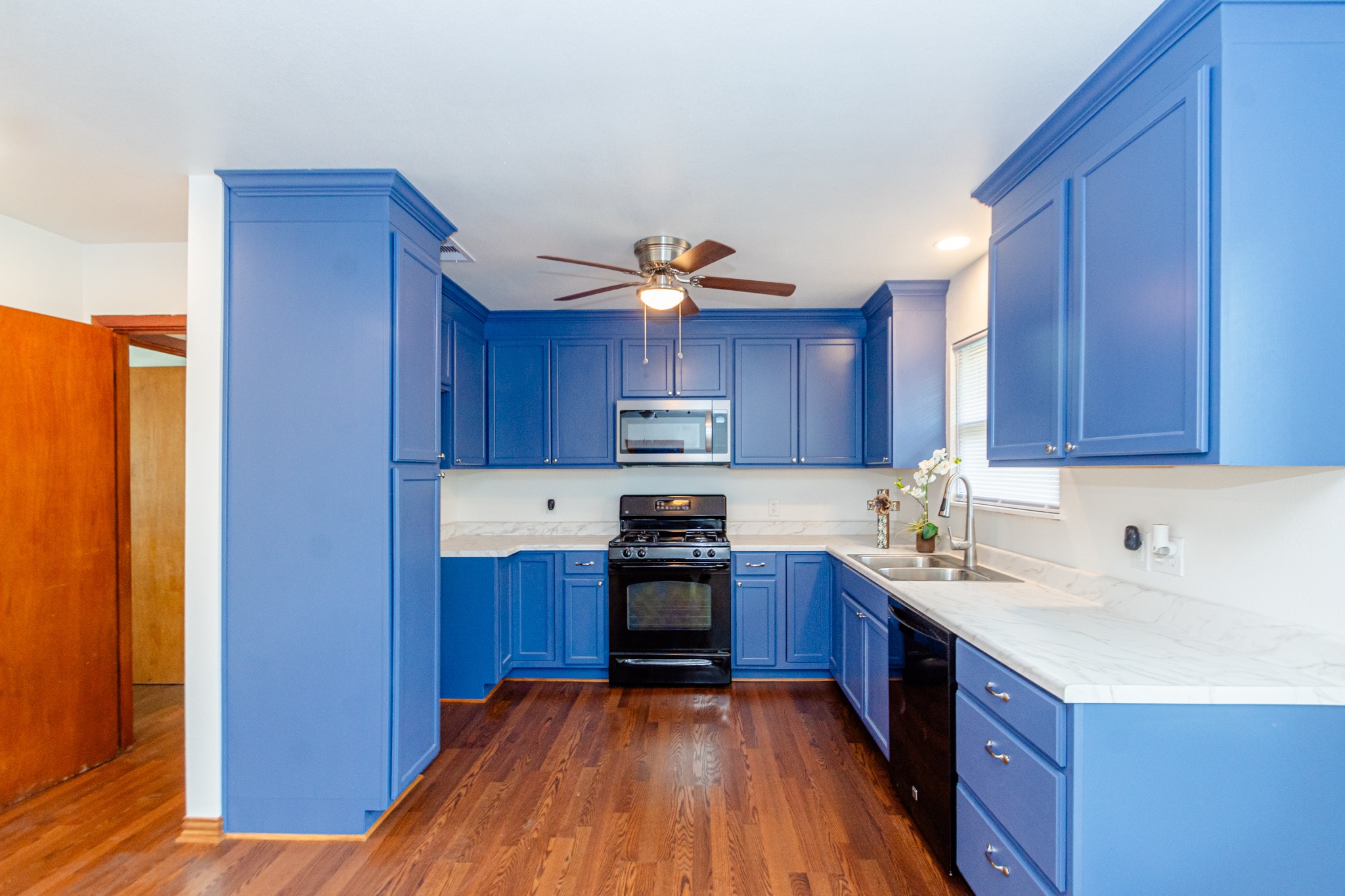 1007 Earley Street Sweeny, TX 77480 - Photo 9 of 33 a kitchen with wooden floors and wooden cabinets