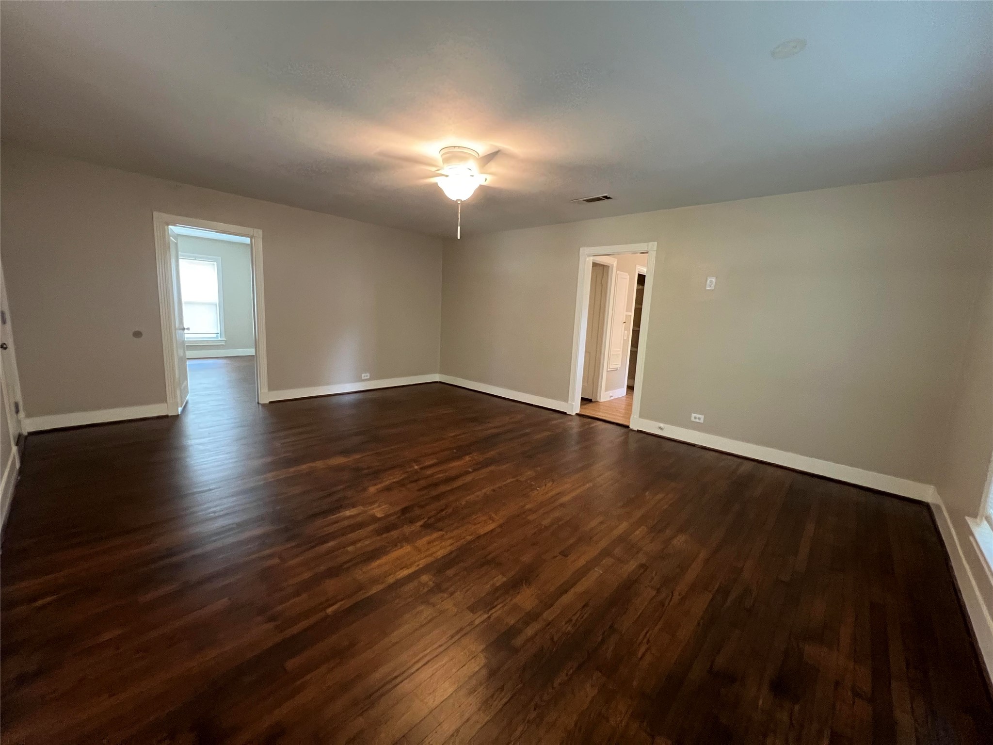 613 Koehl Street Wharton, TX 77488 - Photo 8 of 10 an empty room with wooden floor and windows