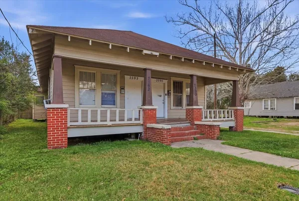 a view of a house with a yard and sitting area