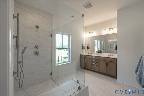 a bathroom with a granite countertop sink a mirror and a shower
