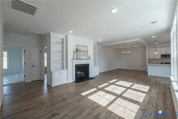 a view of empty room with wooden floor and fireplace