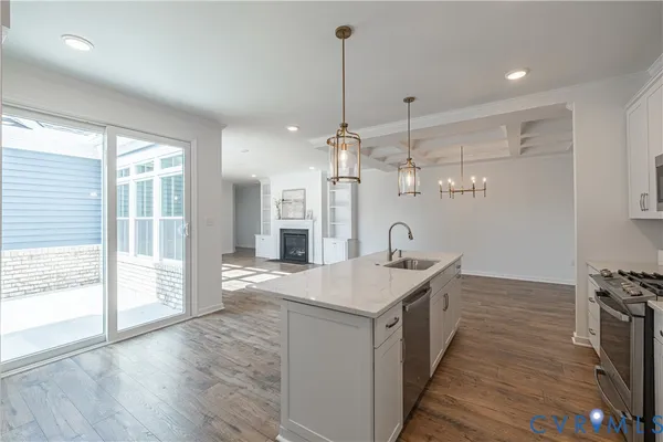 a kitchen with stainless steel appliances granite countertop a sink a oven a stove and a wooden floors