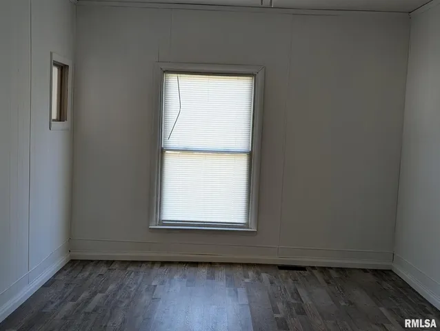 an empty room with wooden floor and a window