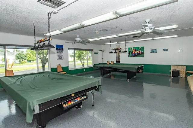 a room with pool table and windows