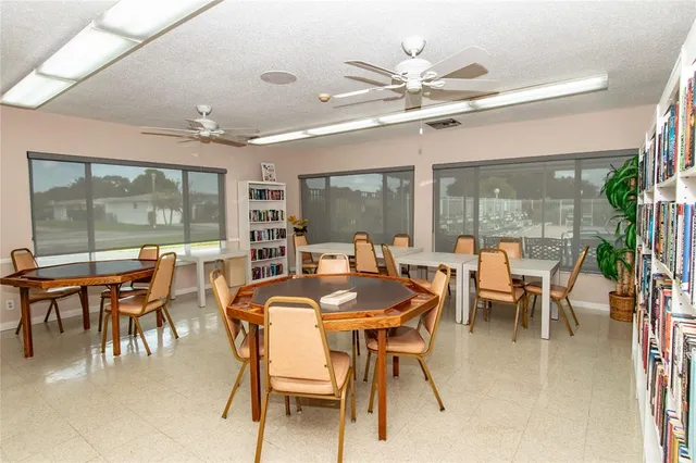 a dining room with furniture a chandelier and a floor to ceiling window