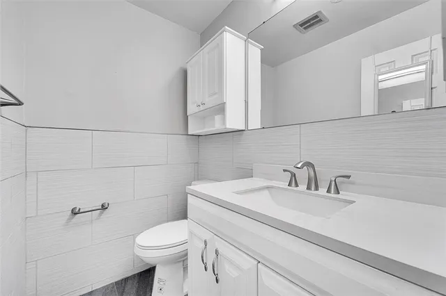 a bathroom with a sink a toilet and mirror