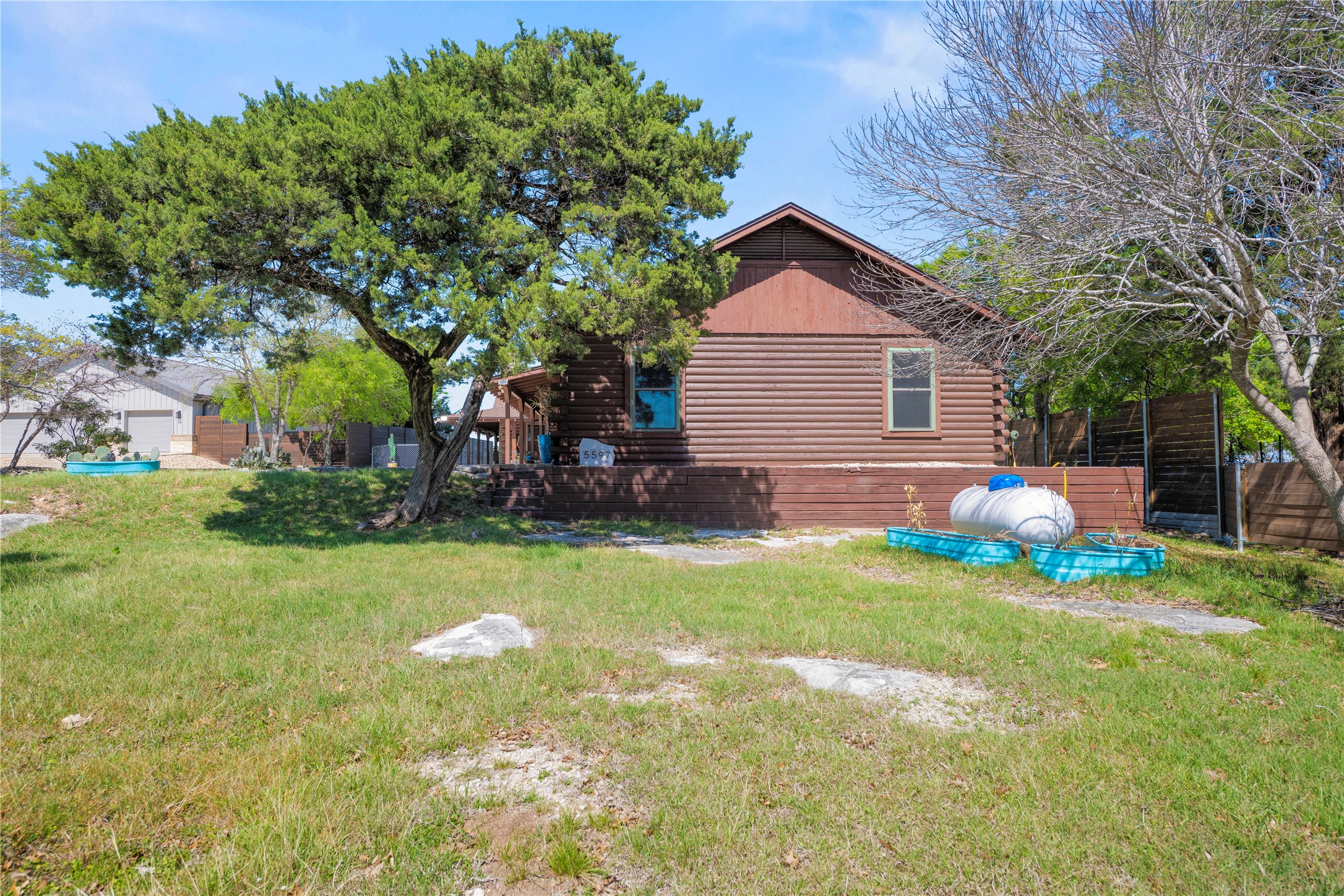 5597 Cliff Lane Temple, TX 76502 - Photo 4 of 38 a backyard of a house with plants and large tree